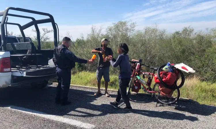 Guardia Estatal apoya con hidratación, comida y seguridad a cicloviajeros japoneses